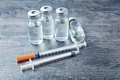 Vaccine in vials with syringes on grunge background